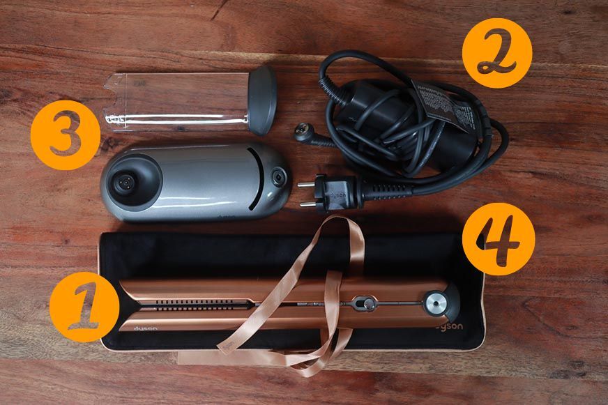 Man sieht den Lieferumfang des Dyson Corrale. 